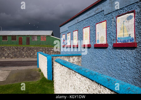 Peint naïf windows sur un Pebble Dash et de tôle ondulée hut en Laytown, comté de Meath, Irlande Banque D'Images