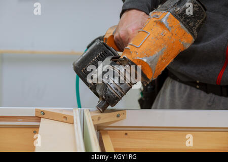 L'homme construit meubles dans l'atelier de menuiserie. homme recueille des informations de meubles dans l'atelier de menuiserie. utilise un pistolet professionnel une autre vue fermer Banque D'Images