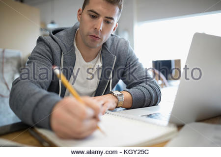 Homme d'affaires créatif et concentré écrivant sur un ordinateur portable