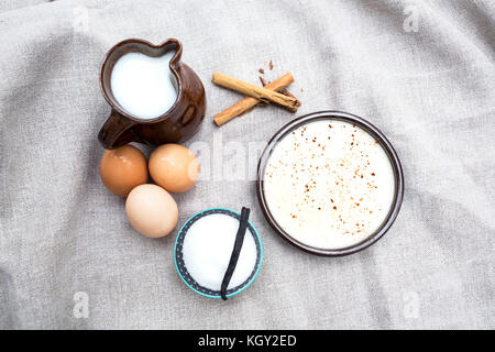 Délicieux dessert crème anglaise avec les ingrédients avec lesquels il est fait que le sucre, les oeufs, le lait et des bâtons de cannelle Banque D'Images