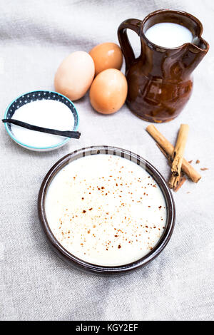 Délicieux dessert crème anglaise avec les ingrédients avec lesquels il est fait que le sucre, les oeufs, le lait et des bâtons de cannelle Banque D'Images