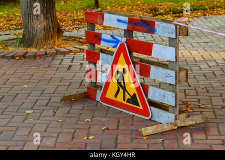 Les travaux en cours. travaux routiers, signalisation routière. l'homme au travail. certaines affiches Affiches pour les travaux en cours sur la rue urbaine. les obstacles et de signalisation routière. silhouette de Banque D'Images