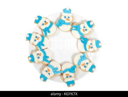 Le SNOWMAN sugar cookies décorés de marshmallow fondant, le glaçage royal bleu foulard et chapeau disposées en cercle sur une assiette de porcelaine. isolated on white Banque D'Images