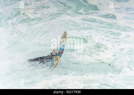 Wipeout sur surfers une entrée dans l'eau loin des rochers à Bronte Beach à Sydney, NSW, Australie Banque D'Images