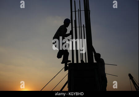 Dhaka, Bangladesh. 10 nov, 2017 travailleurs de la construction du Bangladesh. Silhouette sur coucher de soleil comme ils les travailleurs sur un chantier de bâtiment dans le proscrit de Dhaka. crédit : md. mehedi hasan/zuma/Alamy fil live news Banque D'Images