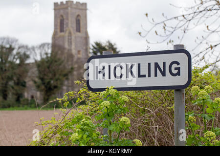 Route de village signe avec l'église Sainte Marie de l'arrière-plan. VILLAGE HICKLING, Norfolk, Broadland. L'East Anglia. ENGLAND UK. Remarque Alexanders vert frais Banque D'Images