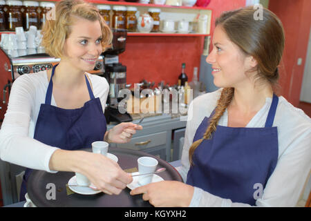 Deux femmes travaillant dans coffee house en uniforme Banque D'Images