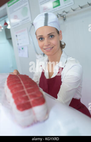 Portrait of happy female butcher standing in shop Banque D'Images