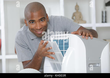 L'homme avec l'appareil de climatisation mobile Banque D'Images