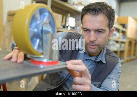 Homme dans un entrepôt est de vérifier les niveaux de stock de marchandises Banque D'Images