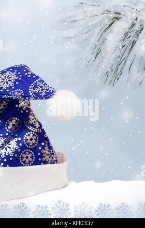 Décorées avec des flocons de blue hat santa claus sur la neige sur fond de pins couverts de neige et de flocons de rangs de la direction générale. Banque D'Images