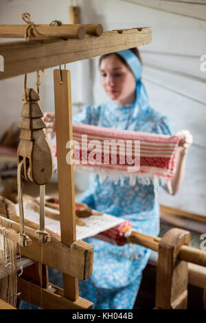 La femme est le tissage du coton coloré robe robe ou par l'aide à tisser en bois dans le village local en Russie Banque D'Images