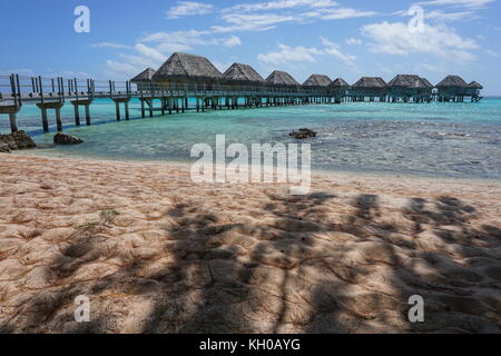 Lagune tropicale avec des bungalows sur pilotis d'un resort vu d'une plage de sable avec de l'ombre des arbres, Tikehau, Tuamotu, Polynésie française, l'océan pacifique Banque D'Images