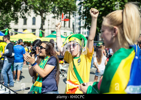 Deux Brésiliens tuent le temps d’attente en jouant au foot de table et s’échauffent pour la Coupe du monde de la FIFA lors de la « Journée du Brésil » à Trafalgar Square à Londres. On dirait que nous avons un gagnant. ROYAUME-UNI 12/06 2014. Banque D'Images