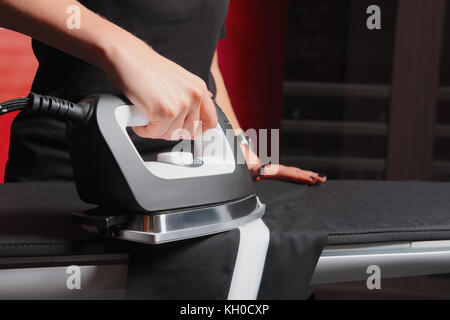 Vêtements de repassage. hand holding repasser à la vapeur. Banque D'Images