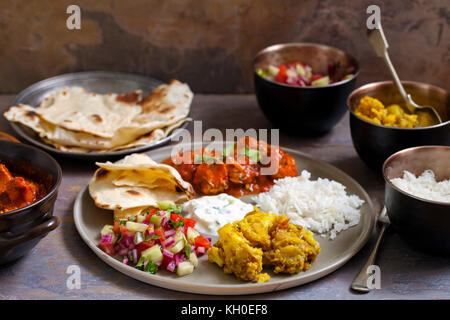 Repas indien avec du poulet tikka masala, Aloo Gobi, salade, riz et pain plat Banque D'Images