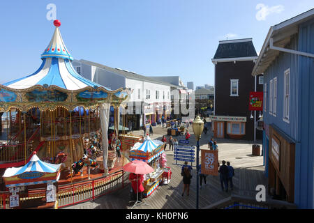 Les touristes et les visiteurs passent devant un manège vintage dans le Pier 39 au Fisherman's Wharf à San Francisco, États-Unis, le 14 septembre 2017. Le Pier 39, qui fait partie du Fisherman's Wharf au nord de San Francisco, était autrefois une jetée. De nos jours, il est rempli de magasins de souvenirs, manèges, restaurants et un aquarium. Photo : Alexandra Schuler/dpa Banque D'Images