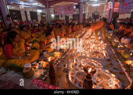 Dhaka, Bangladesh. 12 novembre 2017. Les dévots assister à la prière avec de l'encens et la lumière des lampes à huile avant de rompre le jeûne pendant une Rakher Upobash festival religieux appelé à Dhaka le 12 novembre 2017. Les gens bengali de la foi hindoue au Bangladesh s'asseoir dans la prière pour célébrer le 18e siècle saint hindou Baba Lokenath avec un Rakher Upobas «» la prière et jour de jeûne chaque année des milliers de dévots hindous se rassembler devant Shri Shri Brahmachari Lokenath temple de l'Ashram pour le Rakher Upobash Kartik Brati ou fête religieuse à Dhaka, au Bangladesh. Credit : Azim Khan Ronnie/Alamy Live News Banque D'Images