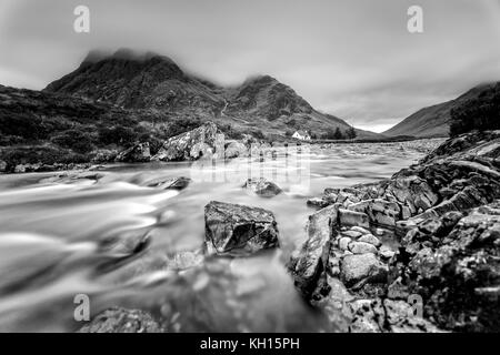 Maison solitaire à Glencoe dans les montagnes de l'Ecosse en noir et blanc Banque D'Images