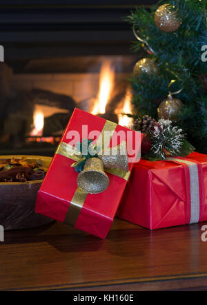 Deux cadeaux de Noël rouge avec une cheminée et d'arbres en arrière-plan Banque D'Images