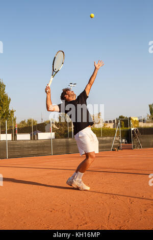 Joueur de tennis professionnel de faire un kick sur cour dans l'après-midi. Banque D'Images