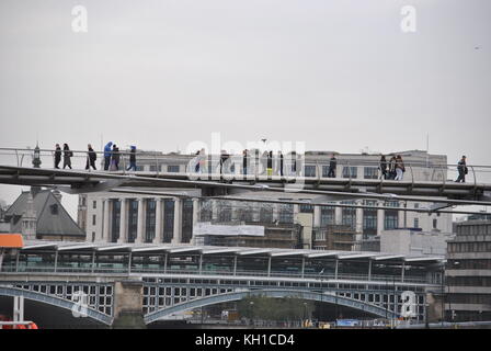 Piétons traversant le Millennium Bridge à Londres, pris d'un bateau sur la Tamise à Londres Banque D'Images