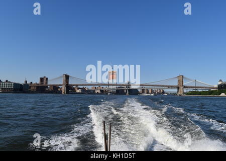 En regardant vers les ponts de Brooklyn et de Manhattan depuis un bateau sur la rivière East, y compris un gratte-ciel en construction, New York City Banque D'Images