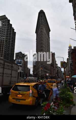 L'homme sortant de taxi jaune, et de la fonte en face de l'horloge Flatiron Building, New York City. Banque D'Images