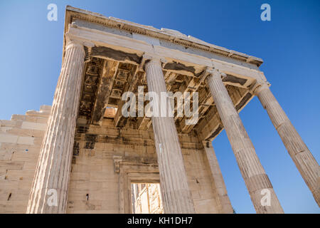 À la recherche à travers des colonnes de marbre au plafond finement sculptés d'une partie de l'Erechtheion sur l'Acropole à Athènes et de ciel bleu. Banque D'Images