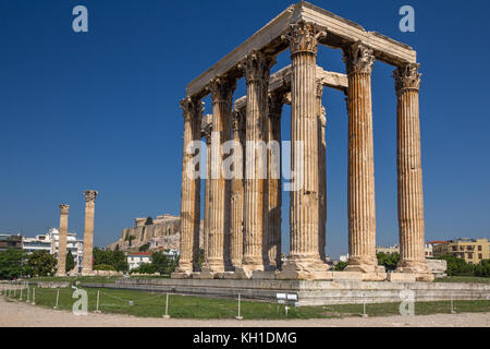 Vue diagonale des vestiges du temple de Zeus à Athènes. En arrière-plan, le Parthénon se trouve au sommet de l'Acropole. Banque D'Images