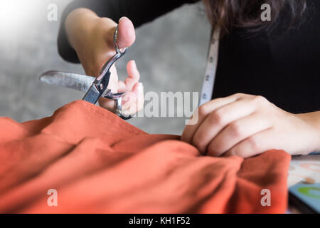 Encoche mains du tailleur sur mesure tissu ciseaux couper un morceau de tissu (Fashion designer concept) Banque D'Images