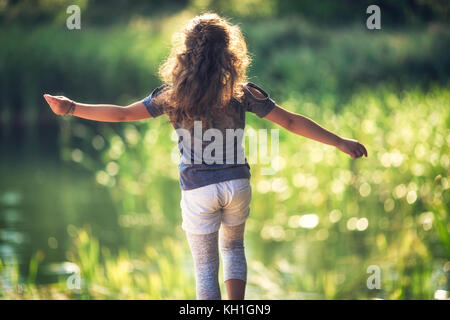 Happy little girl appréciant la nature et la journée ensoleillée dans le parc Banque D'Images