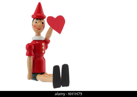 Pinocchio toy statue et coeur isolé sur fond blanc. Concept de la Saint-Valentin. Banque D'Images