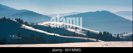 Superbe panorama hivernal de collines enneigées. beau paysage avec des montagnes boisées à une distance Banque D'Images