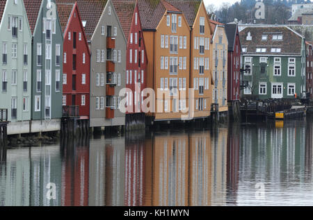 Les entrepôts en bois convertis debout sur les pieux en bois sur les rives de la rivière Nidelva. Trondheim, Sør-Trøndelag, Norvège. Banque D'Images