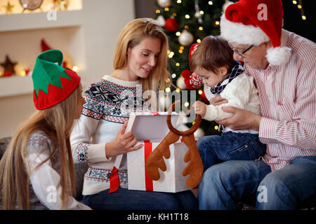 Les dépenses de la famille heureux temps de Noël les cadeaux d'ouverture Banque D'Images