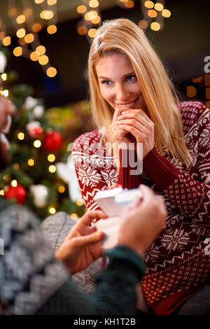 Jeune femme surprise hommes avec test de grossesse positif pour cadeau de Noël Banque D'Images