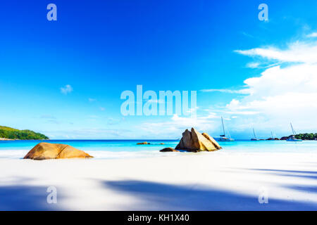 Rêve pittoresque plage avec sable blanc, rochers de granit doré et les catamarans dans l'eau turquoise et un ciel bleu à l'anse lazio à Praslin Island sur Banque D'Images