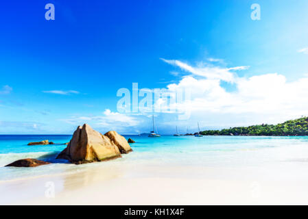 Rêve pittoresque plage avec sable blanc, rochers de granit doré et les catamarans dans l'eau turquoise et un ciel bleu à l'anse lazio à Praslin Island sur Banque D'Images