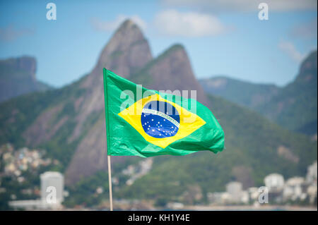 Brésil drapeau à la brise en face de deux frères montagne sur la plage d'Ipanema à Rio de Janeiro. Banque D'Images