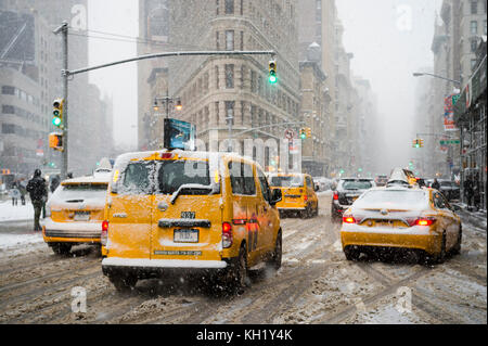 New York City - 7 janvier 2016 : une tempête d'hiver apporte le trafic et les piétons à une lente ramper au Flatiron building sur la cinquième avenue. Banque D'Images