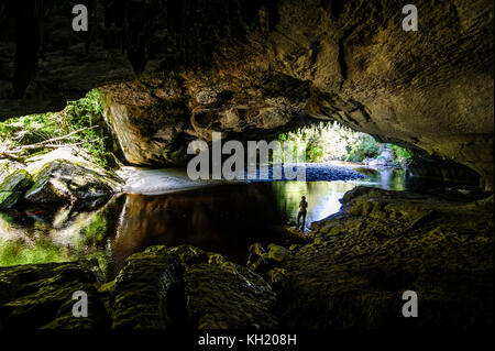 Woman la magnifique porte de la moria arch dans le bassin, oparara karamea, île du Sud, Nouvelle-Zélande Banque D'Images