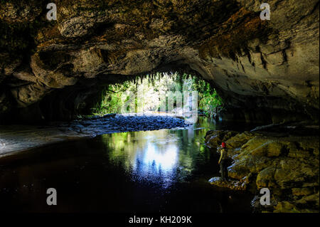 Woman la magnifique porte de la moria arch dans le bassin, oparara karamea, île du Sud, Nouvelle-Zélande Banque D'Images