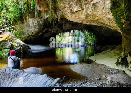 Woman la magnifique porte de la moria arch dans le bassin, oparara karamea, île du Sud, Nouvelle-Zélande Banque D'Images