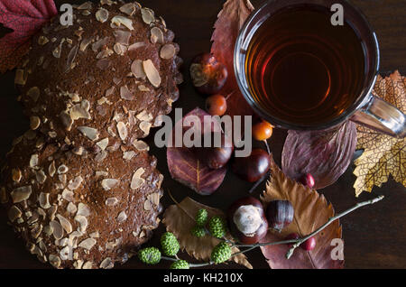 Gros plan du décor d'automne avec une tasse de thé et des biscuits aux épices, sur fond de bois Banque D'Images