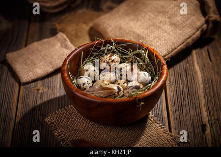 Des oeufs de cailles dans bol en bois sombre sur fond de bois vieux Banque D'Images