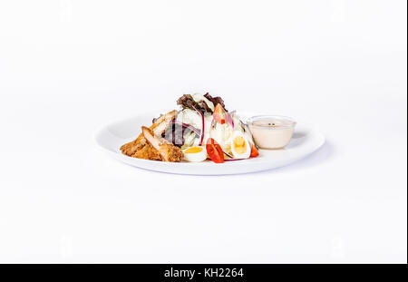 Pan-asiatique de la salade, des légumes et des œufs de poulet frit avec. sur une plaque blanche sur fond blanc. Banque D'Images