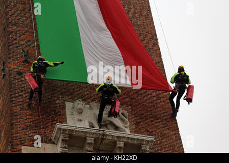 Vicenza, VI, Italie - 4 décembre 2015 : Les pompiers avec un grand drapeau italien et la tour d'un palais appelé Basilique palladienne au cours d'un exercice Banque D'Images