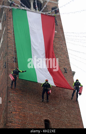 Vicenza, VI, Italie - 4 décembre 2015 : Les pompiers avec un grand drapeau italien et la tour de l'ancien palais appelé Basilique palladienne au cours d'un exerc Banque D'Images