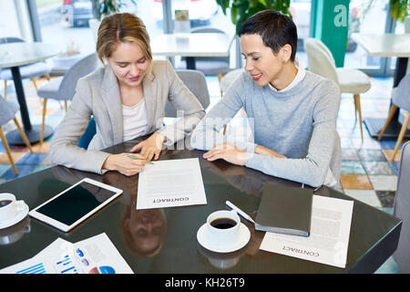 High angle portrait of two businesswomen signature contrat sitting at table in modern office Banque D'Images